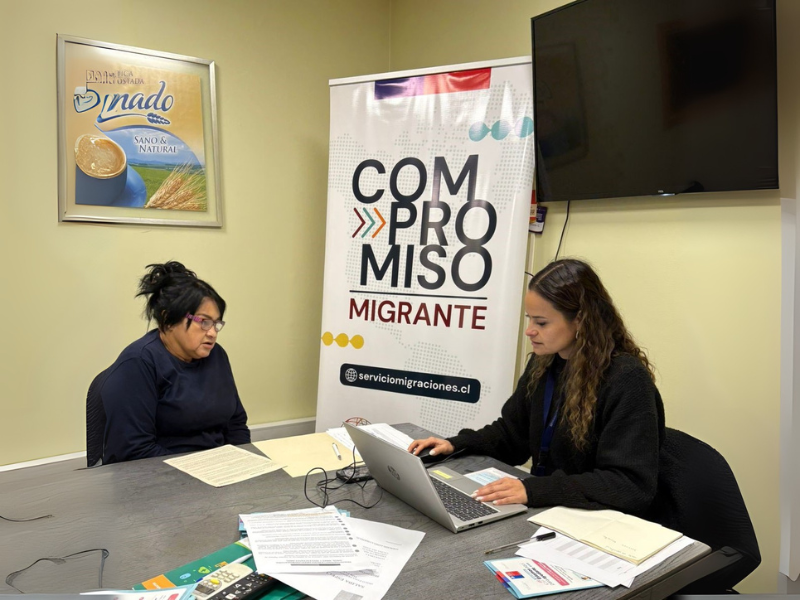 Funcionaria de SERMIG junto a persona migrante siendo informada