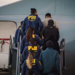 Primera expulsión extranjeros. Oficiales de PDI acompañando a abordar al avión a personas irregulares.