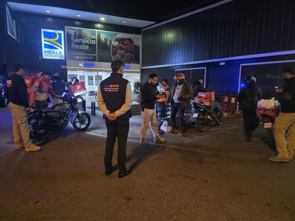 Personal de la PDI y SERMIG fiscalizan a personas migrantes en las afueras de un centro comercial