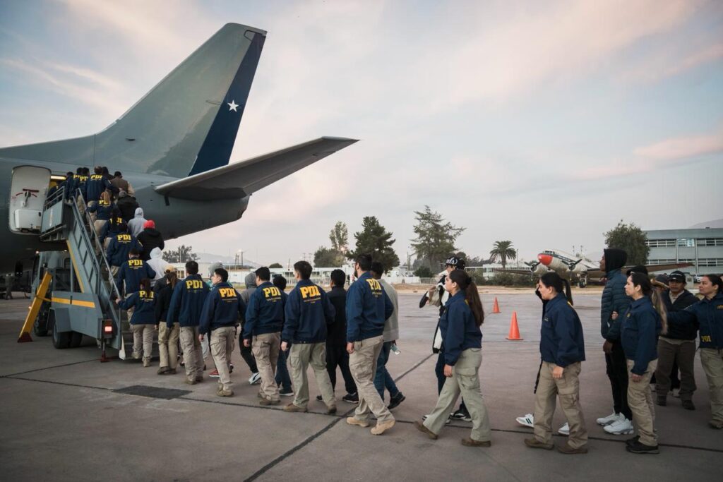 Extranjeros con orden de expulsión en fila embarcando el avión para regresar a su país.